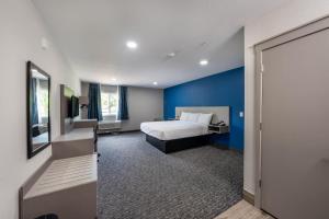 a bedroom with a bed and a blue wall at Hummingbird Hotel in Goodlettsville