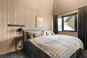 a bedroom with a bed and a window at Large modern cabin from 2023 for rent in Dirdal