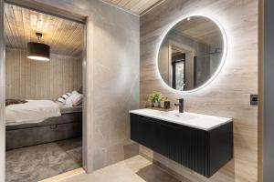 a bathroom with a sink and a mirror and a bed at Large modern cabin from 2023 for rent in Dirdal +22 photos