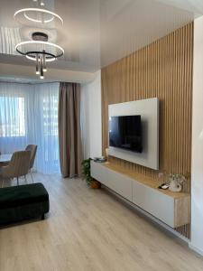 a living room with a flat screen tv on a wall at TheBlueEscape Apartment in Năvodari