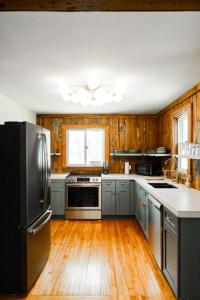a kitchen with wooden floors and a black refrigerator at Family Fun Indoor Play Zone UP Waterfalls in Bessemer