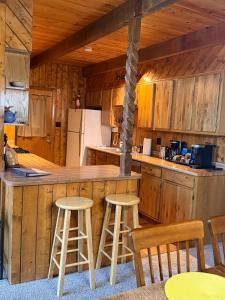 a kitchen with a counter and stools in a cabin at Elevation Station Surrounded by Wildlife in Angel Fire