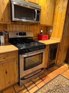 a kitchen with a stove and a microwave at Elevation Station Surrounded by Wildlife in Angel Fire +13 photos