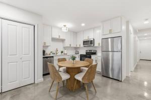 a kitchen with a table and chairs and a refrigerator at Decantur Inn 3 King Bedrooms in Lafayette