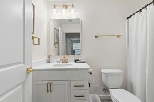 a white bathroom with a sink and a mirror at Decantur Inn 3 King Bedrooms in Lafayette +16 photos