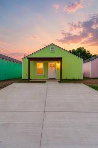 a green garage with a sunset in the background at Decantur Inn 3 King Bedrooms in Lafayette