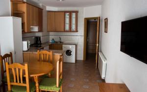 a kitchen with a table and a dining room at La flor del cerezo in Piornal