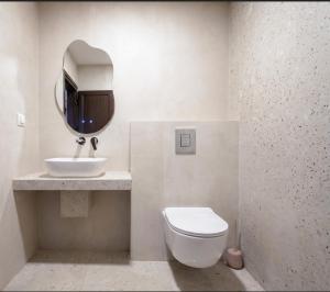 a bathroom with a sink and a toilet and a mirror at Golden Beach Apartment in Nea Moudania +17 photos