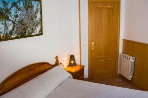 a bedroom with a bed with a wooden head board at La flor del cerezo in Piornal