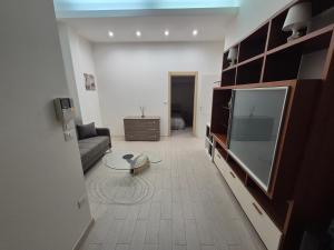 ein Wohnzimmer mit Sofa und Flachbildfernseher in der Unterkunft desHouse in Molfetta