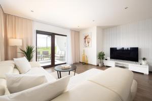 a living room with a white couch and a television at Dům Pavlov in Pavlov