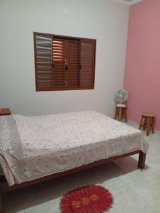 a bedroom with a bed and a window at Casa da Helenice in São Roque de Minas