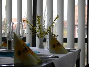 a table with a white table cloth and flowers on it at Hotel Landhaus Moritzburg in Moritzburg