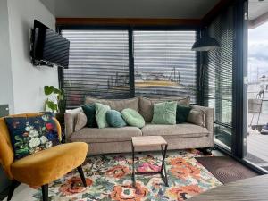 a living room with a couch and a large window at Houseboat De Amstel in Monnickendam