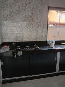 a kitchen with a stove and a counter top at Casa da Helenice in São Roque de Minas
