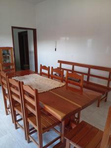 a dining room with a wooden table and chairs at Casa da Helenice in São Roque de Minas