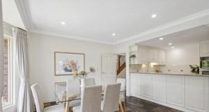 a kitchen and dining room with a table and chairs at MawsonLakes Lake view Villa in Mawson Lakes