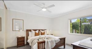 a bedroom with a bed with a ceiling fan at MawsonLakes Lake view Villa in Mawson Lakes +9 photos