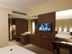 a bathroom with a television in a hotel room at Louis Tavern Hotel in Bangkok