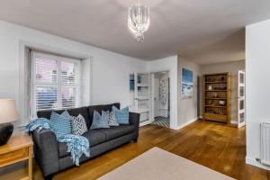 a living room with a couch and a table at Pear Tree Cottage, Dunblane in Dunblane