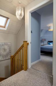 a hallway of a home with a staircase and a chandelier at Pear Tree Cottage, Dunblane in Dunblane