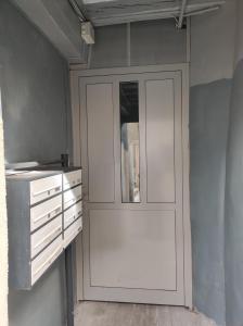 a kitchen with white cabinets and a door at L'escapade CDG Astérix Parc d'exposition in Louvres +11 photos