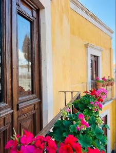a balcony with flowers on a window ledge at Casa Luminara in Guanajuato