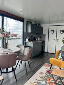 a kitchen and living room with a table and chairs at Houseboat De Amstel in Monnickendam