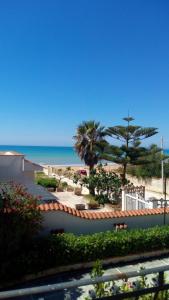 a view of a beach with palm trees and the ocean at Villa Maricla in Marinella di Selinunte