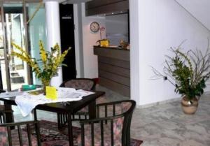 a dining room with a table and chairs and a kitchen at Hotel Landhaus Moritzburg in Moritzburg +2 photos