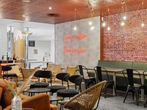 a restaurant with chairs and tables and a brick wall at Novotel Paris Est Centre de Conférence in Bagnolet