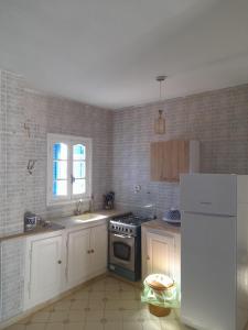 a kitchen with a stove and a sink and a refrigerator at Taguermess Tag 5 in Taguermess