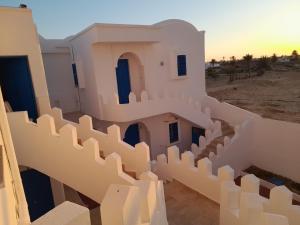 a view of a building in the desert with a sunset at Taguermess Tag 5 in Taguermess