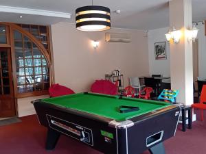 a room with a pool table and red chairs at Hôtel La Gravenne in Thueyts