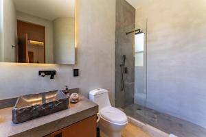 a bathroom with a toilet and a shower and a sink at Elements Rituals Beachfront Bahia Soliman Tulum in Tulum