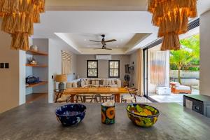 a kitchen and living room with a wooden table at Elements Rituals Beachfront Bahia Soliman Tulum in Tulum