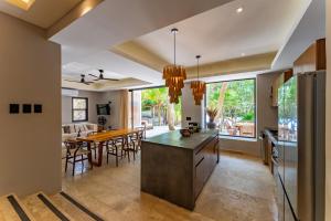 a kitchen and dining room with a table and chairs at Elements Rituals Beachfront Bahia Soliman Tulum in Tulum