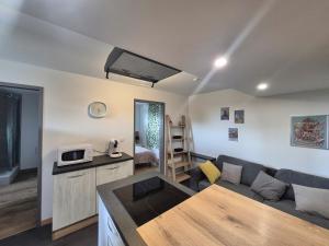 a living room with a couch and a kitchen at Cocon moderne et chaleureux in Craon