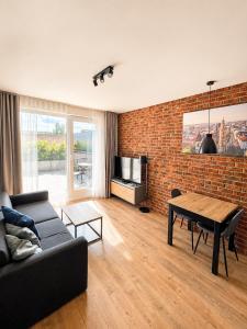 a living room with a couch and a table and a brick wall at AH Terrace Jacuzzi Suite near Arena in Košice