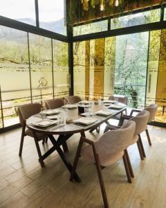 a dining room with a table and chairs and windows at Grotto Resort & Restaurant in Quba