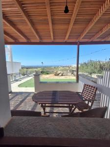 a patio with a table and a bench on a porch at Manolas Sunset View in Glinádhon