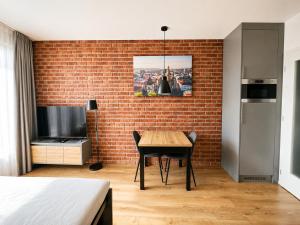 a room with a table and a brick wall at AH Terrace Jacuzzi Suite near Arena in Košice +2 photos