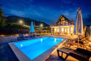a pool with chairs and umbrellas next to a house at Villa Ksenija with Private Pool- Peace & Privacy in Bar