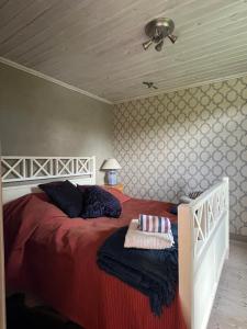 a bedroom with a large bed with a red blanket at Solkulla Matskog in Kulla