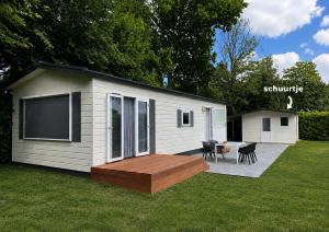 a small shed with a deck and a patio at 't Vrolijke Uusje in Scharendijke