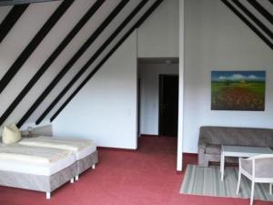 a bedroom with a bed and a table and chairs at Hotel Landhaus Moritzburg in Moritzburg