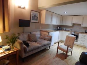 a living room with a couch and a kitchen at Drummond Apartment in Edinburgh