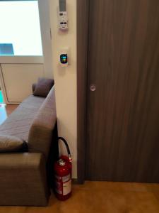 a door with a fire extinguisher next to a bed with a fire hydrant at brezza marina in Siderno Marina