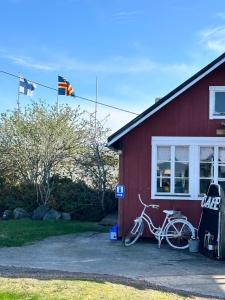 a white bike parked outside of a red house at Sandvik Gästhamn & Camping in Kökar