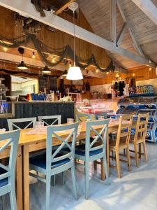 a dining room with a wooden table and chairs at Sandvik Gästhamn & Camping in Kökar +26 photos